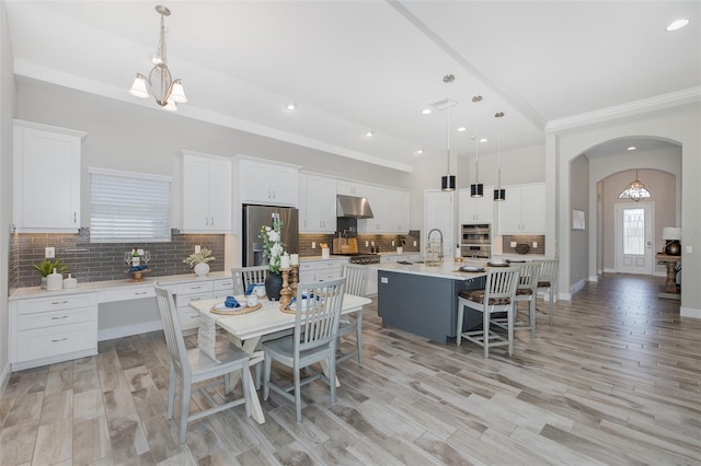 5070 Night Star Trl, Odessa, FL 33556 - dining room featuring arched walkways, recessed lighting, crown molding, light wood-type flooring, and a chandelier