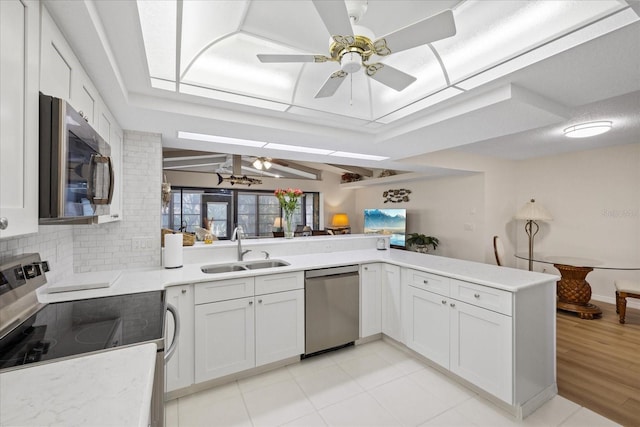 4504 Dewey Dr, New Port Richey, FL 34652 - kitchen featuring appliances with stainless steel finishes, a ceiling fan, light countertops, tasteful backsplash, and white cabinets