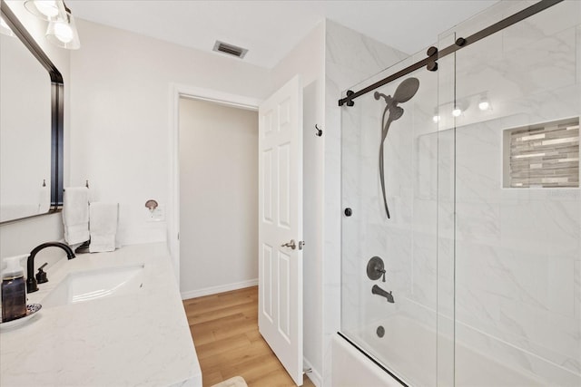 4504 Dewey Dr, New Port Richey, FL 34652 - bathroom with bath / shower combo with glass door, vanity, and wood finished floors