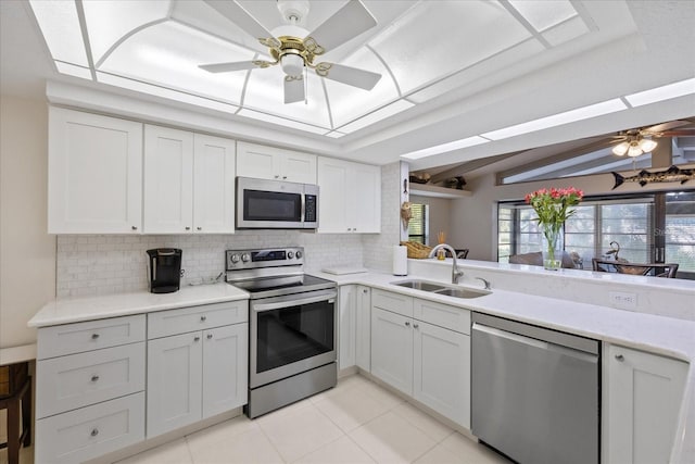 4504 Dewey Dr, New Port Richey, FL 34652 - kitchen featuring stainless steel appliances, ceiling fan, backsplash, light tile patterned floors, and lofted ceiling
