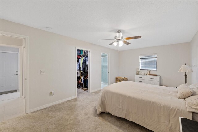 4504 Dewey Dr, New Port Richey, FL 34652 - bedroom featuring light carpet, a spacious closet, ensuite bath, a closet, and a ceiling fan