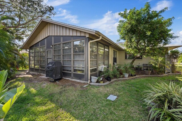 4504 Dewey Dr, New Port Richey, FL 34652 - view of side of home featuring a sunroom and a lawn