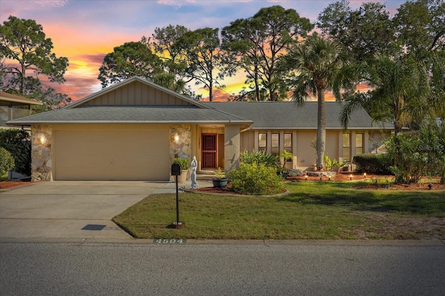 4504 Dewey Dr, New Port Richey, FL 34652 - ranch-style house featuring driveway, a garage, a yard, a shingled roof, and stone siding