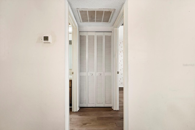 hall featuring wood finished floors and visible vents