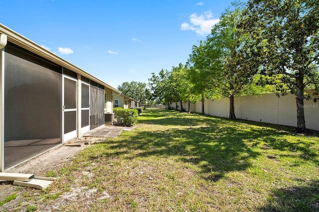 view of yard featuring a sunroom and a fenced backyard