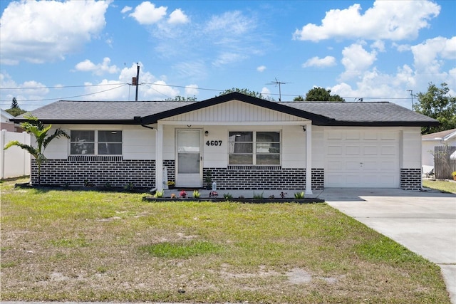 4607 Kennedy Dr, New Port Richey, FL 34652 - view of front facade featuring roof with shingles, a porch, concrete driveway, an attached garage, and a front yard