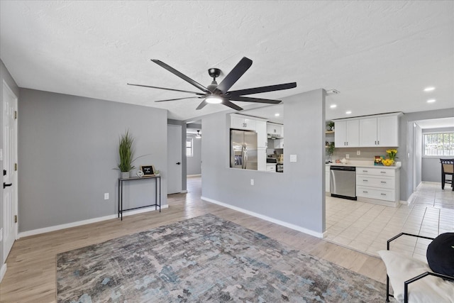 4607 Kennedy Dr, New Port Richey, FL 34652 - interior space with light wood finished floors, stainless steel appliances, a textured ceiling, and white cabinetry