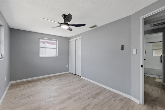 4607 Kennedy Dr, New Port Richey, FL 34652 - unfurnished bedroom with wood finished floors, visible vents, a closet, baseboards, and a textured ceiling