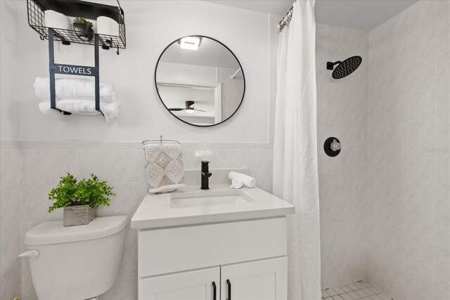 4607 Kennedy Dr, New Port Richey, FL 34652 - bathroom featuring tile walls, toilet, vanity, and tiled shower