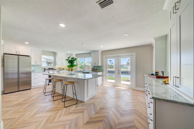 6432 Boatyard Dr, Hudson, FL 34667 - kitchen featuring recessed lighting, appliances with stainless steel finishes, a kitchen island, a kitchen bar, and visible vents