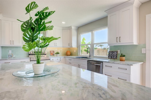 6432 Boatyard Dr, Hudson, FL 34667 - kitchen featuring stainless steel dishwasher, light stone counters, a sink, and white cabinetry