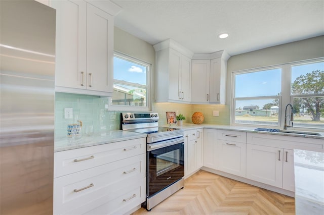 6432 Boatyard Dr, Hudson, FL 34667 - kitchen featuring white cabinets, stainless steel appliances, a healthy amount of sunlight, and a sink