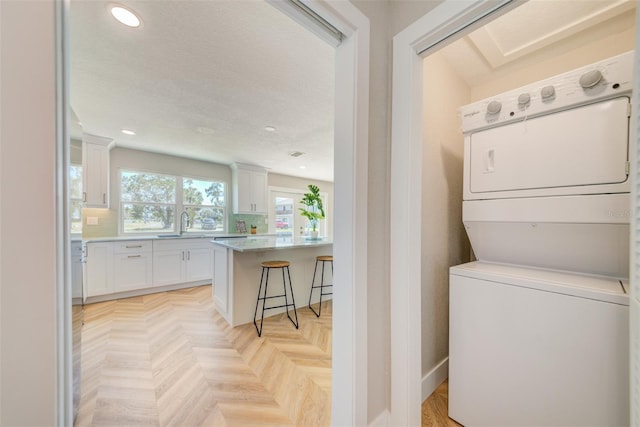6432 Boatyard Dr, Hudson, FL 34667 - laundry area with a sink, stacked washer and clothes dryer, baseboards, recessed lighting, and laundry area