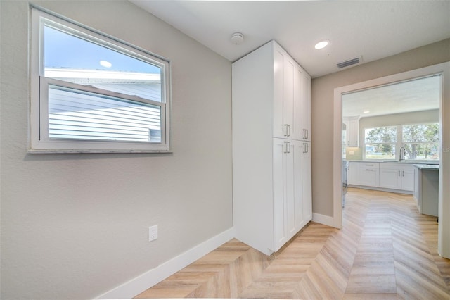 6432 Boatyard Dr, Hudson, FL 34667 - hallway featuring baseboards, visible vents, a sink, and recessed lighting