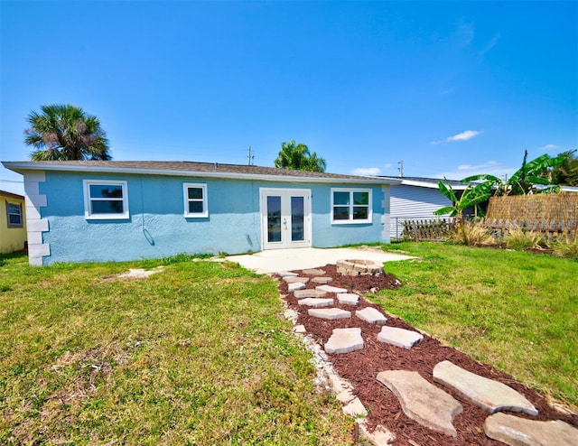 6432 Boatyard Dr, Hudson, FL 34667 - back of property featuring a lawn, a fire pit, stucco siding, and french doors