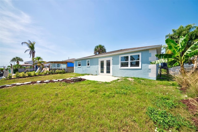 6432 Boatyard Dr, Hudson, FL 34667 - rear view of property with stucco siding, fence, an outdoor fire pit, and french doors