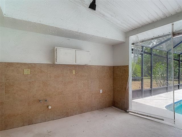 interior space with unfinished concrete flooring and a textured wall