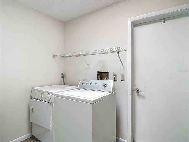 laundry area with washing machine and clothes dryer, baseboards, and laundry area