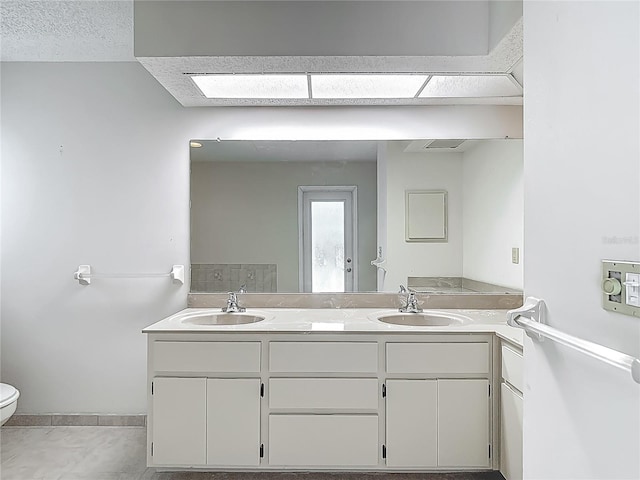 full bath with tile patterned floors, a sink, double vanity, and toilet