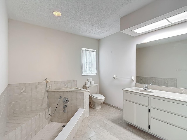 full bathroom featuring a tile shower, a textured ceiling, vanity, and toilet