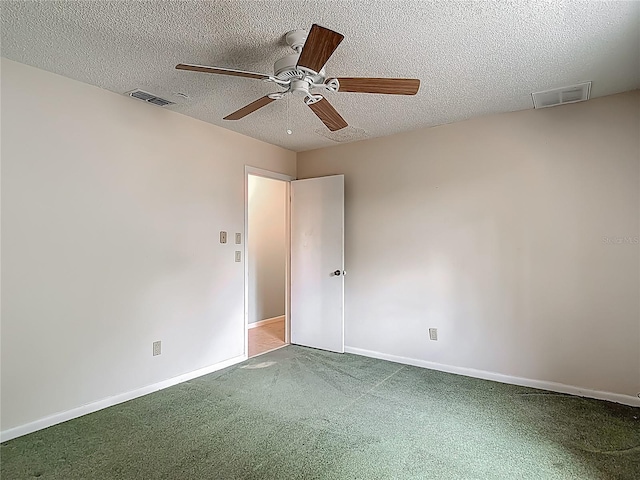 empty room with a ceiling fan, carpet flooring, a textured ceiling, and visible vents