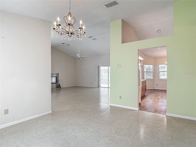 unfurnished room featuring high vaulted ceiling, a textured ceiling, baseboards, a notable chandelier, and visible vents
