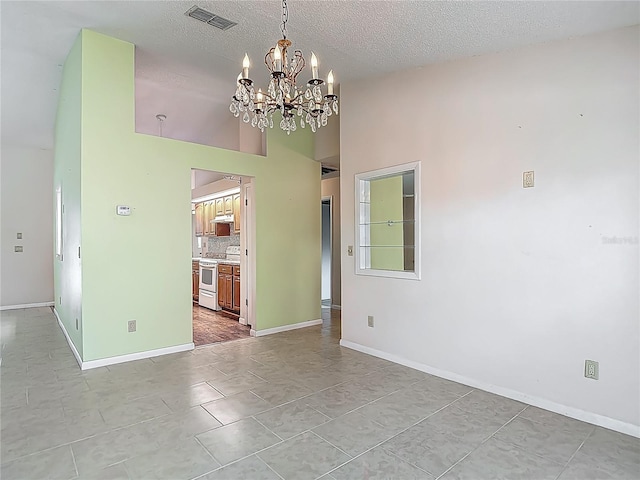 unfurnished dining area featuring baseboards, visible vents, high vaulted ceiling, and a chandelier