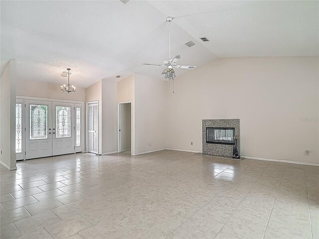 unfurnished living room with a textured ceiling, ceiling fan with notable chandelier, baseboards, a fireplace, and lofted ceiling