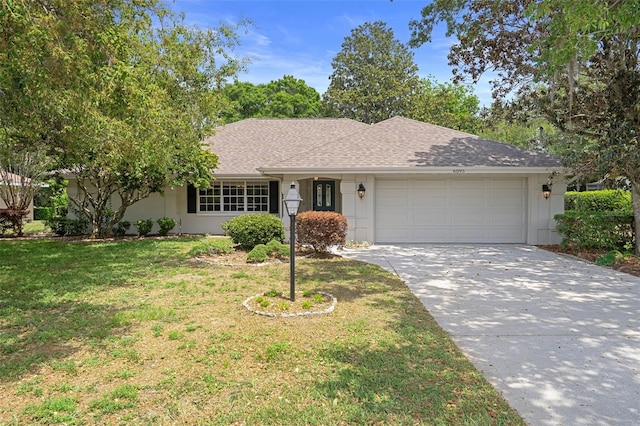 6095 W Douneray Loop, Crystal River, FL 34429 - single story home featuring a garage, driveway, a shingled roof, and a front lawn