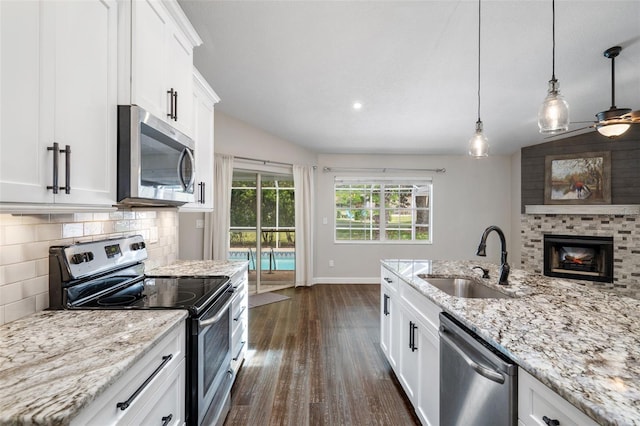 6095 W Douneray Loop, Crystal River, FL 34429 - kitchen with white cabinets, stainless steel appliances, a sink, tasteful backsplash, and dark wood-style flooring