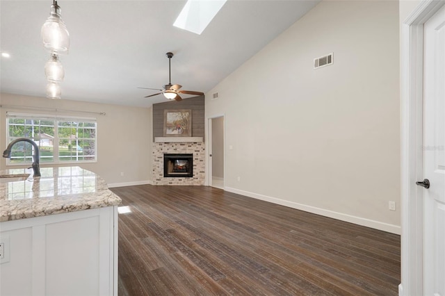 6095 W Douneray Loop, Crystal River, FL 34429 - kitchen with dark wood finished floors, visible vents, a ceiling fan, a sink, and a large fireplace