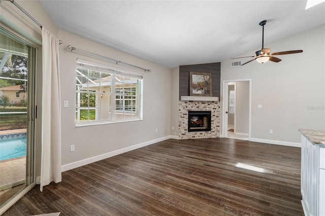 6095 W Douneray Loop, Crystal River, FL 34429 - unfurnished living room with vaulted ceiling, a ceiling fan, visible vents, a fireplace, and dark wood-style floors
