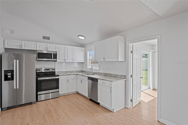 kitchen with white cabinets, stainless steel appliances, visible vents, and a sink