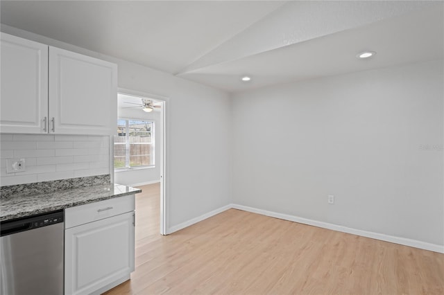 kitchen with lofted ceiling, decorative backsplash, stainless steel dishwasher, and light wood-style flooring