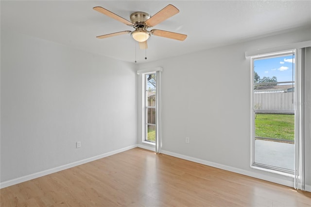 spare room with light wood finished floors, baseboards, and a wealth of natural light