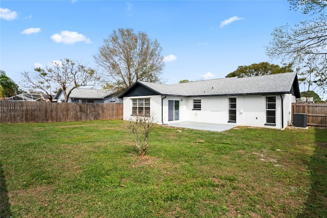 rear view of property featuring central AC unit, a patio area, a fenced backyard, a yard, and stucco siding