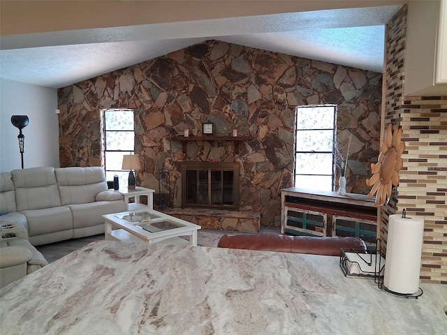 7508 Cypress Knee Dr, Hudson, FL 34667 - living room featuring a textured ceiling, a stone fireplace, and vaulted ceiling