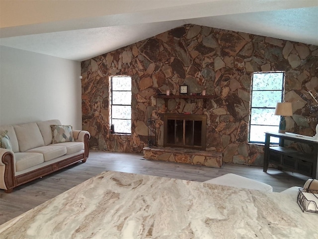 7508 Cypress Knee Dr, Hudson, FL 34667 - living area with lofted ceiling, wood finished floors, a fireplace, and healthy amount of natural light