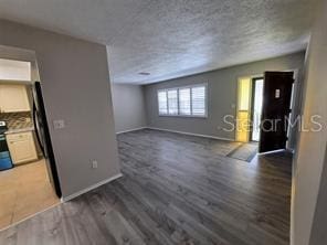 7508 Cypress Knee Dr, Hudson, FL 34667 - unfurnished living room featuring wood finished floors and a textured ceiling