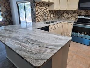 7508 Cypress Knee Dr, Hudson, FL 34667 - kitchen featuring black microwave, stainless steel electric range oven, tasteful backsplash, and plenty of natural light