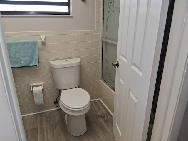 7508 Cypress Knee Dr, Hudson, FL 34667 - bathroom featuring wood finished floors, tile walls, and a wainscoted wall