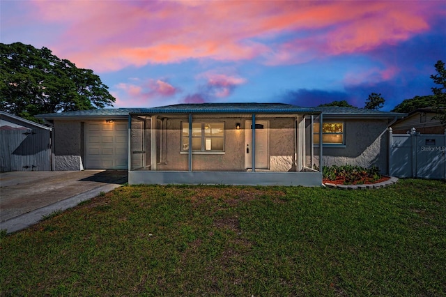 7321 Parrot Dr, Port Richey, FL 34668 - rear view of house with driveway, fence, an attached garage, a lawn, and stucco siding