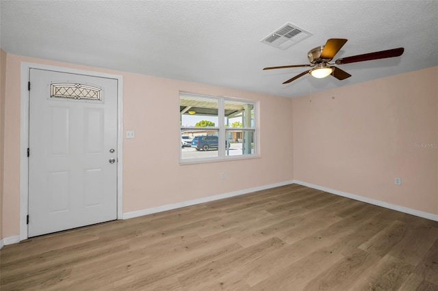 7321 Parrot Dr, Port Richey, FL 34668 - entrance foyer with light wood-style flooring, a textured ceiling, baseboards, visible vents, and ceiling fan