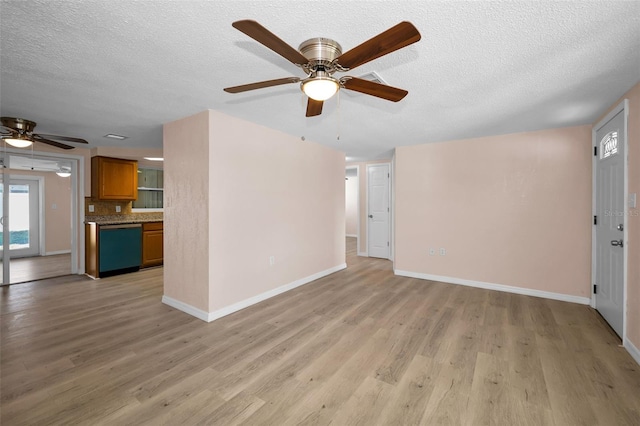 7321 Parrot Dr, Port Richey, FL 34668 - unfurnished living room with light wood-style floors, a textured ceiling, baseboards, and ceiling fan