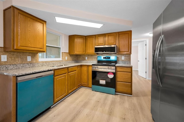 7321 Parrot Dr, Port Richey, FL 34668 - kitchen featuring brown cabinets, appliances with stainless steel finishes, tasteful backsplash, and light wood-style floors