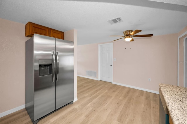 7321 Parrot Dr, Port Richey, FL 34668 - kitchen featuring brown cabinetry, ceiling fan, stainless steel refrigerator with ice dispenser, and visible vents