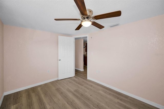 7321 Parrot Dr, Port Richey, FL 34668 - unfurnished room with wood finished floors, visible vents, baseboards, a textured ceiling, and ceiling fan