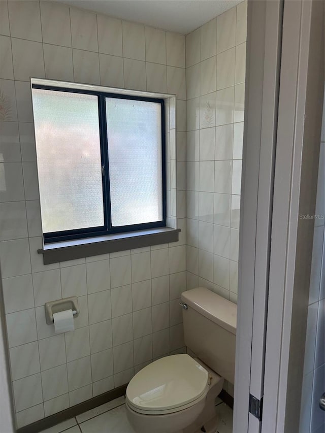 1412 Wexford Dr N, Palm Harbor, FL 34683 - half bathroom with toilet, tile patterned floors, and tile walls