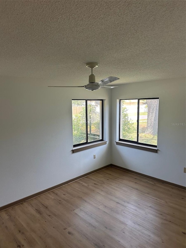 1412 Wexford Dr N, Palm Harbor, FL 34683 - spare room featuring baseboards, a ceiling fan, a textured ceiling, and wood finished floors
