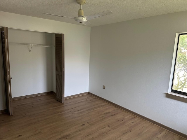 1412 Wexford Dr N, Palm Harbor, FL 34683 - unfurnished bedroom featuring baseboards, multiple windows, a closet, and wood finished floors